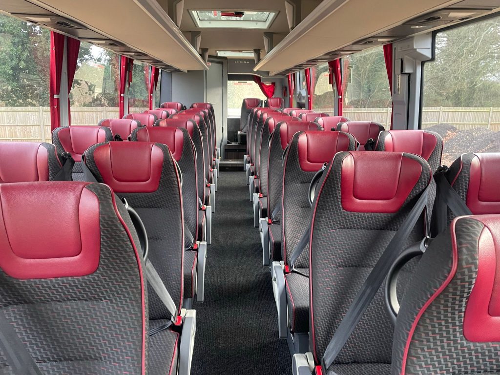 black and red cloth and leather seats on the interior of a 34 seater coach
